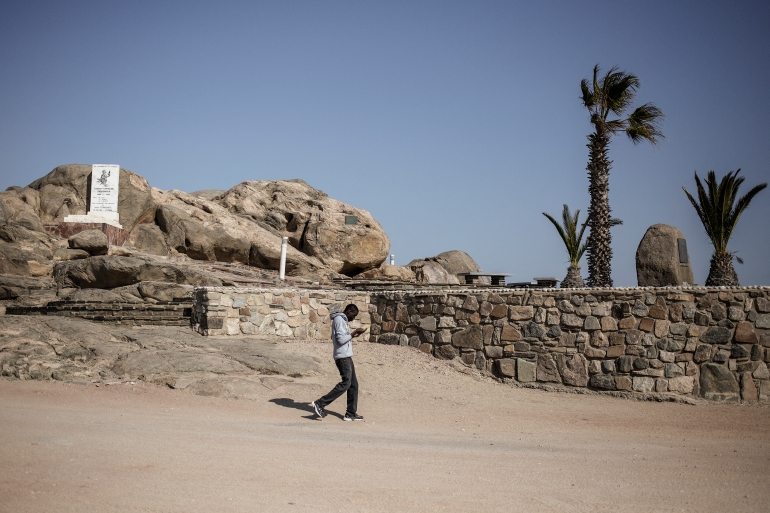 A man walks by a monument in Luderitz remembering the genocide committed by German forces against Herero and Nama [File: Gianluigi Guercia/AFP]