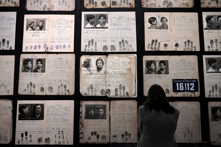 A visitor looks at enlarged identity documents at the exhibition "Barvalo, Roms, Sinti, Manouches, Gitans, Voyageurs" at the Museum of European and Mediterranean Civilisations (Mucem) in Marseille, southern France, on May 9, 2023. (Photo by Nicolas TUCAT / AFP) / RESTRICTED TO EDITORIAL USE - MANDATORY MENTION OF THE ARTIST UPON PUBLICATION - TO ILLUSTRATE THE EVENT AS SPECIFIED IN THE CAPTION - RESTRICTED TO EDITORIAL USE - MANDATORY MENTION OF THE ARTIST UPON PUBLICATION - TO ILLUSTRATE THE EVENT AS SPECIFIED IN THE CAPTION /