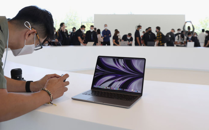 CUPERTINO, CALIFORNIA - JUNE 06: An attendee takes a picture of a newly redesigned MacBook Air laptop during the WWDC22 at Apple Park on June 06, 2022 in Cupertino, California. Apple CEO Tim Cook kicked off the annual WWDC22 developer conference. (Photo by Justin Sullivan/Getty Images)