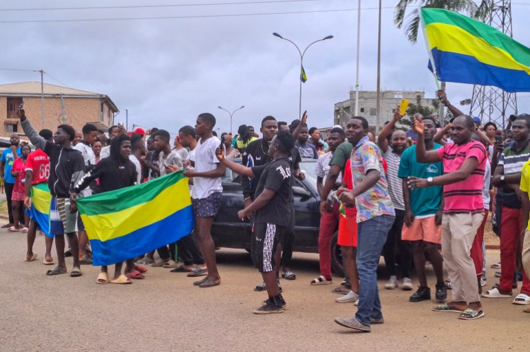 epa10828170 People display the Gabon national flag as they celebrate in the streets of Akanda, Gabon, 30 August 2023. Members of the Gabonese army on 30 August announced on national television that they were canceling the election results and putting an end to Gabonese President Ali Bongo's regime, who had been declared the winner. EPA-EFE/STRINGER