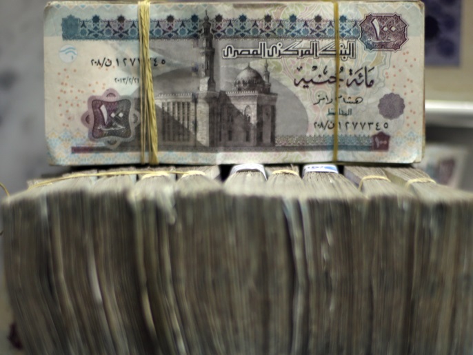 Egypt's pound notes are pictured in stacks of 100 as employees count money at an exchange office in downtown Cairo June 5, 2014. Egypt's currency black market is under threat from two directions, as aid from wealthy Gulf states promises to ease a dollar shortage and an increasingly confident central bank engineers a gradual depreciation of the Egyptian pound. REUTERS/Amr Abdallah Dalsh (EGYPT - Tags: POLITICS BUSINESS)